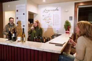 Winemaker Pietro Buttitta, left, looks on as Debbie Harley, center, smells a wine at the Local Vines tasting room in Lafayette. Don Feria For the S.F. Chronicle